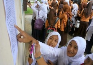 HARIAN ACEH | RAHMAD KELANA Para siswi SMP Negeri 6 Lampineung Banda Aceh melihat pengumuman kelulusan yang ditempel di dinding sekolahnya, Sabtu (4/6). Jumlah kelulusan ujian nasional (UN) siswa SMP/MTs se Aceh tahun 2011 mencapai 99,13 persen.